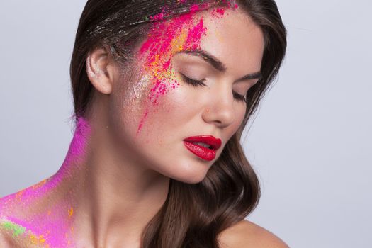 Beautiful woman face with colorful powder makeup closeup