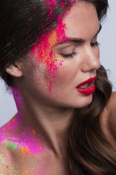 Beautiful woman face with colorful powder makeup closeup