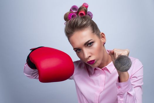 Fighting for beauty concept, funny woman with in boxing glove holding make-up brush