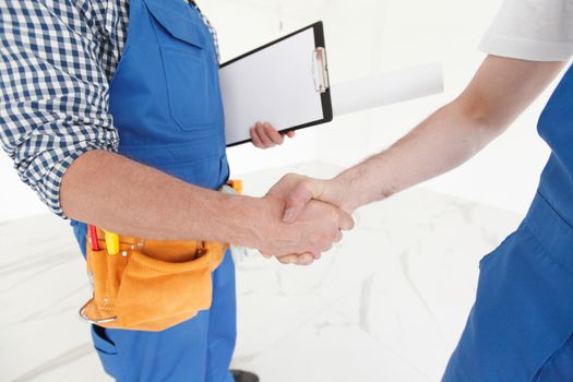 Two construction workers shaking hands, deal is finished , employment concept