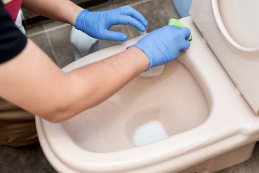 Man cleaning toilet bowl