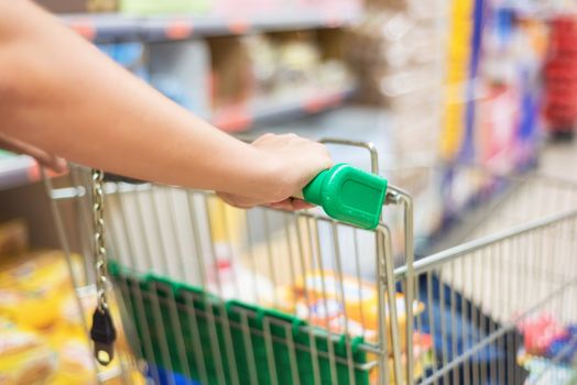 man pushing shopping cart in supermarket store abstract blur background.