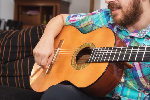 Young man musician playing acoustic guitar