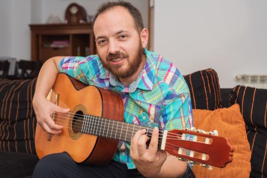 Young man musician playing acoustic guitar