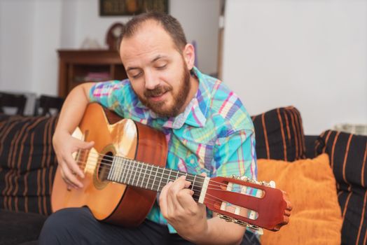 Young man musician playing acoustic guitar