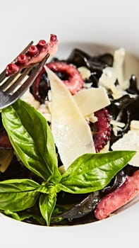 Pasta with black cuttlefish ink, octopuses and parmesan