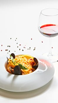 The cooked mussels and pasta with wine glass