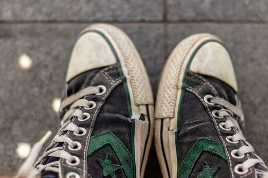 old converse all-star shoes with green star and wales on it. a closeup shoot with both foot.