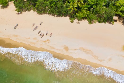 Aerial view of boats moored on the beach, Caribbean beach with waves.