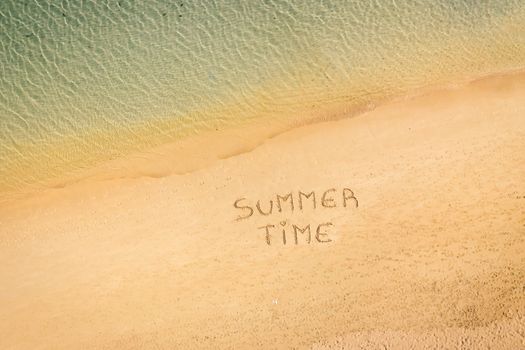 aerial view of the inscription on the sand "Summer Time", Caribbean beach and ocean seen from above