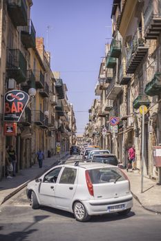 View of a street in the village of Gela with its daytime life in the south of Sicily in Italy.