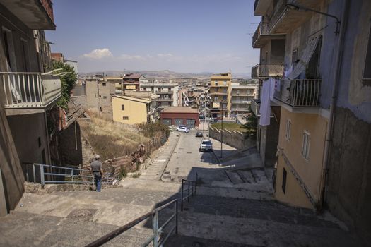 View of a street in the village of Gela with its daytime life in the south of Sicily in Italy.