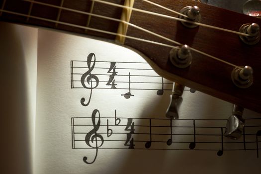 Music notes and ukulele in morning light. Closeup and copy space for text. Concept of Music lovers.