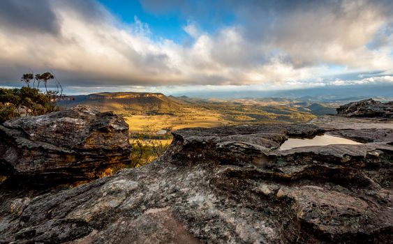 Ever changing light and  weather across the Blue Mountains landscape and its rippling hills and valleys as viewed from a rocky clifftop.  Some views can only be witnessed after a bushwalk like this one.