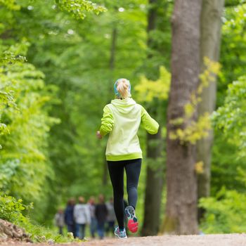 Sporty young female runner in forest. Running woman. Female runner during outdoor workout in nature. Fitness model outdoors. Weight Loss. Healthy lifestyle.