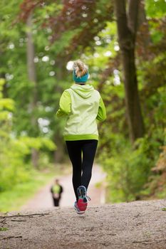 Sporty young female runner in forest. Running woman. Female runner during outdoor workout in nature. Fitness model outdoors. Weight Loss. Healthy lifestyle.