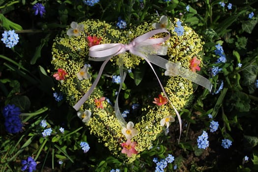 The pictureshows a romantic heart in spring flowers.