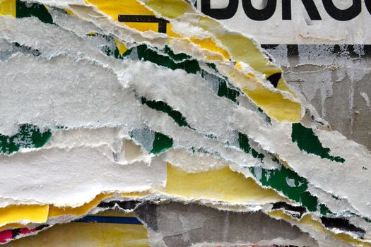 A colourful photo of textures created by layers of torn advertising posters on a billboard background