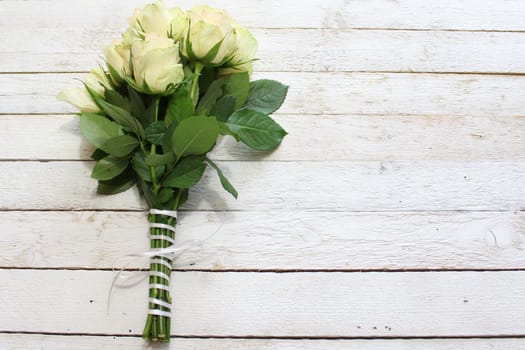 The picture shows white roses on wooden boards.