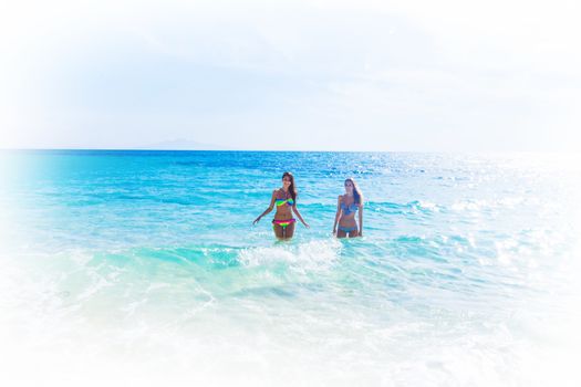 Beautiful fit women in bikni run on tropical beach