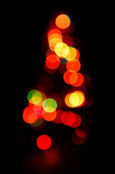 Bokeh silhouette of Christmas tree on black background