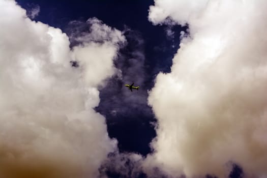 Airplane flying in the sky surround by clouds.