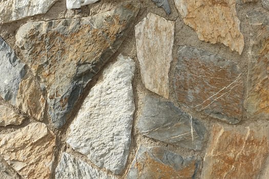 A stone wall of raw stone. Texture of stone.