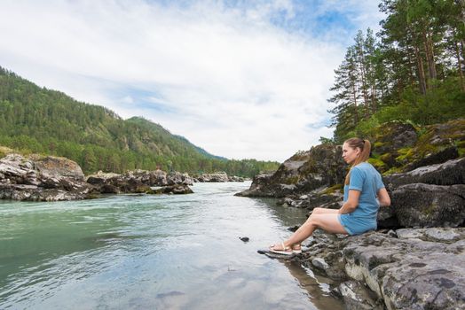 Woman resting at river in Altai Mountains territory