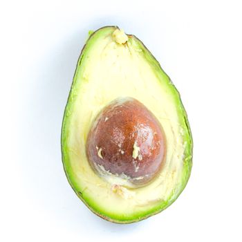 Close-up single half cut of avocado isolated on white background. Ripe organic Persea Americana, healthy fat fruit