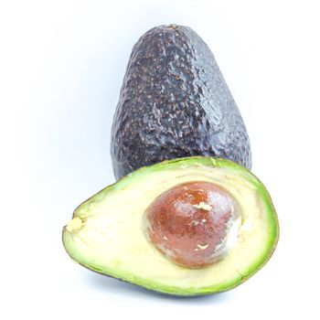 Close-up whole and half cut of avocado isolated on white background. Ripe organic Persea Americana, healthy fat fruits