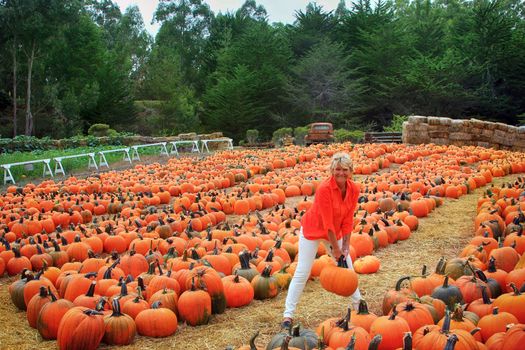 cheerful woman with pumpkin on a farm