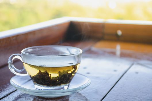 Cup with tea on table over mountains landscape with sunlight. Beauty nature background