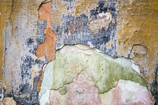 Old damaged wall with layers of colors.