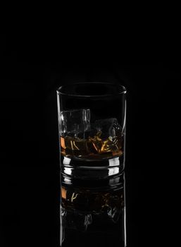 Alcohol.Wwhiskey with ice on a black background