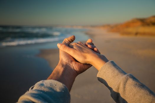 Couple holding hand on the beach