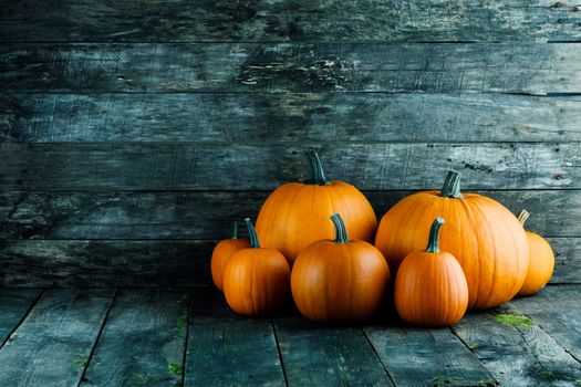 Many orange pumpkins on dark wooden background, Halloween concept