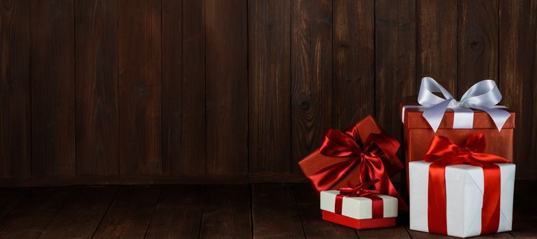 Packages of holiday Christmas gifts on dark wooden background