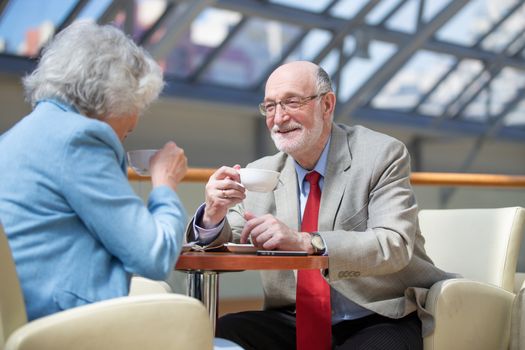 Senior Couple Enjoying Coffee In Cafe