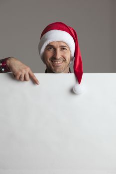 Happy man in Santa hat holding blank banner with copy space