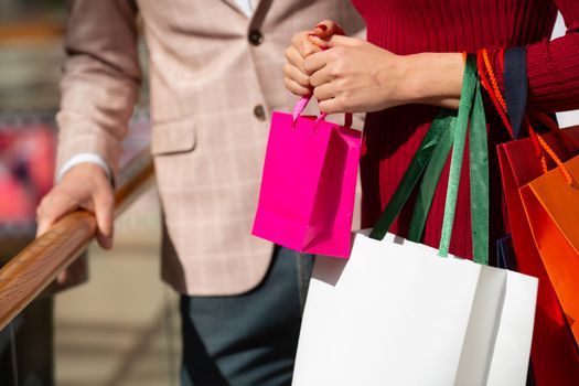 Close up of couple hands holding shopping bags