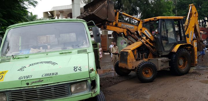Pune, India - September 26, 2019: Government City Corporation workers help to clear the destruction done by floods in India.