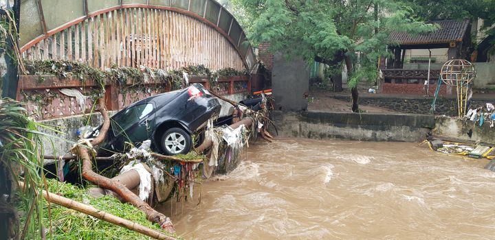 A car which got carried with floods water stuck in a bridge in India.