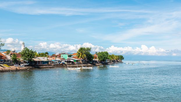 Singaraja in North Bali, Indonesia. Mosque on the left and traditional fishing boats called jukung.