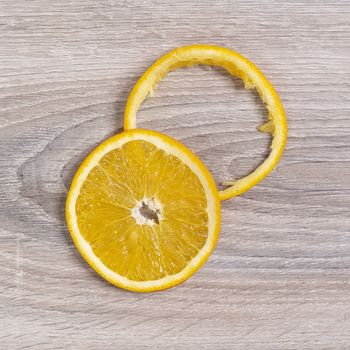 on a slice and an orange peel on a wooden table