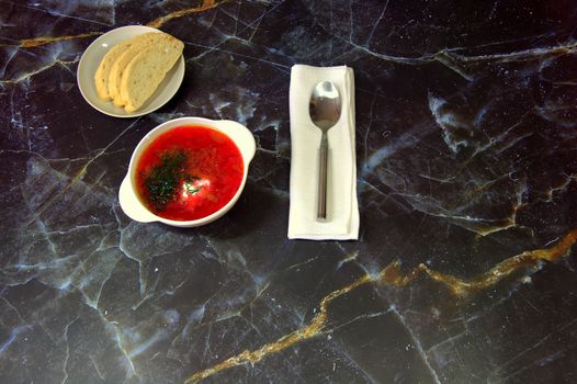 Traditional Russian soup Borsch , white bread and a spoon on a napkin. Close-up.