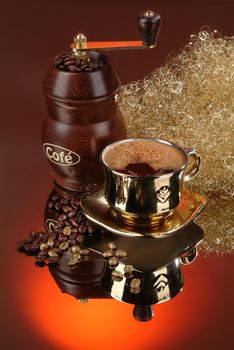 Cup of coffee, mill and golden web on a glass background
