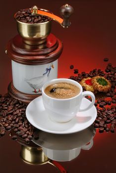 Cup of coffee, mill and cakes on a glass background