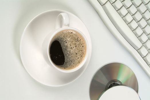 Cup of coffee, DCs and keyboard on a studio background