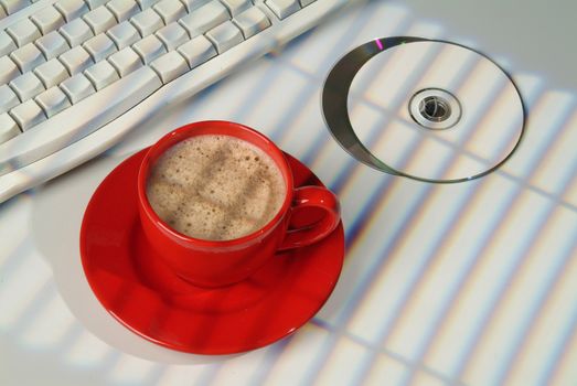 Cup of coffee, DCs and keyboard on a studio background