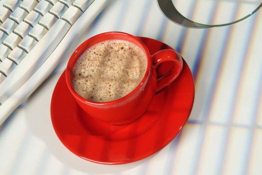 Cup of coffee, DCs and keyboard on a studio background